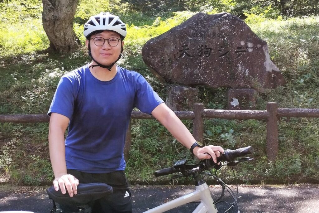 Finding serenity in rural Hiroshima's natural splendor. Our East Asian guest enjoys a moment of pure contentment amidst nature's beauty.